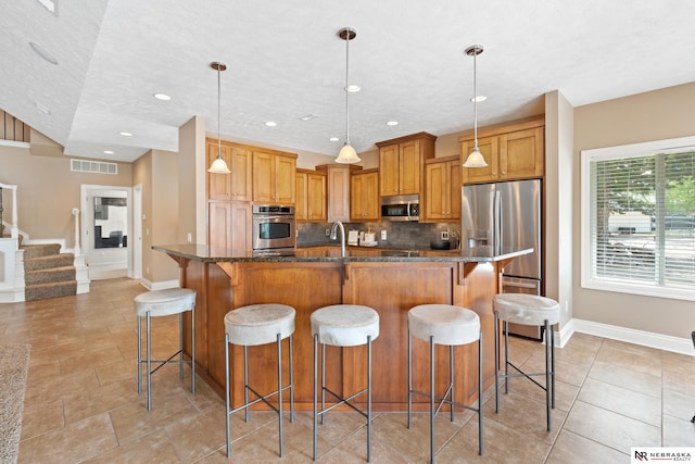 S-1007 Shady Ln, Fremont, NE 68025 - kitchen with appliances with stainless steel finishes, decorative backsplash, baseboards, a breakfast bar area, and recessed lighting