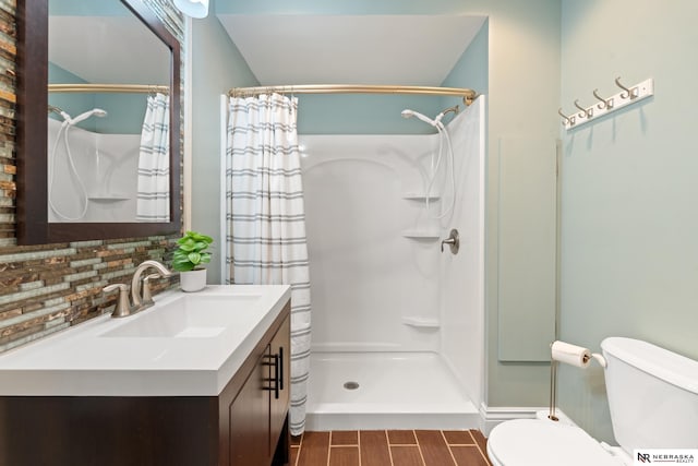 S-1007 Shady Ln, Fremont, NE 68025 - full bathroom with toilet, a shower with curtain, tasteful backsplash, vanity, and wood finished floors