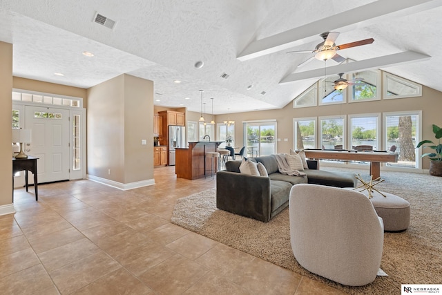 S-1007 Shady Ln, Fremont, NE 68025 - living room with ceiling fan, baseboards, light tile patterned floors, a textured ceiling, and vaulted ceiling