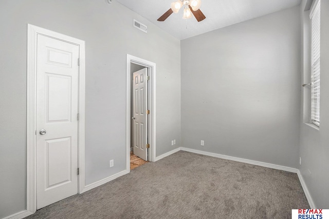 unfurnished bedroom with carpet flooring, baseboards, visible vents, and ceiling fan