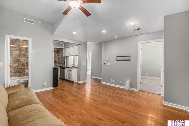 unfurnished living room with visible vents, a sink, ceiling fan, and recessed lighting
