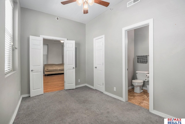 unfurnished bedroom with visible vents, carpet, ensuite bathroom, and baseboards