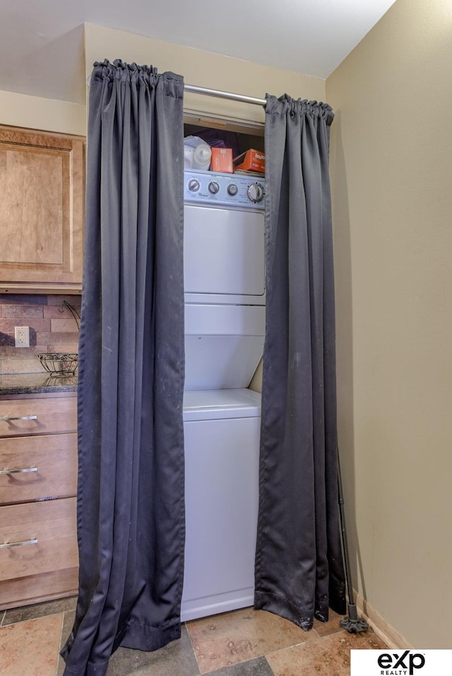 clothes washing area featuring laundry area and stacked washer and clothes dryer