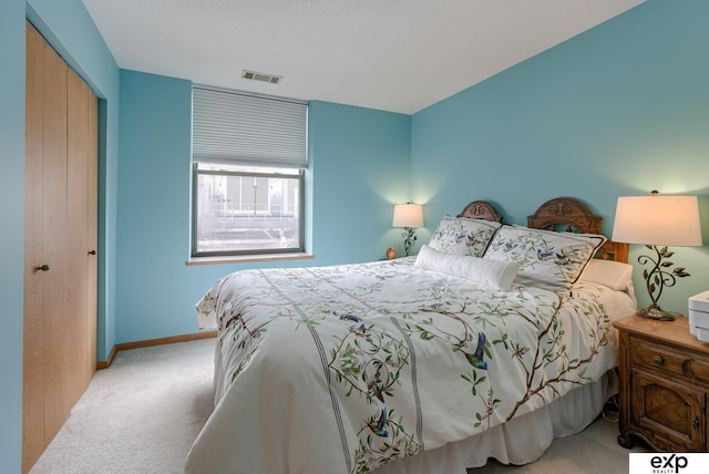 bedroom featuring carpet floors, baseboards, visible vents, and a closet