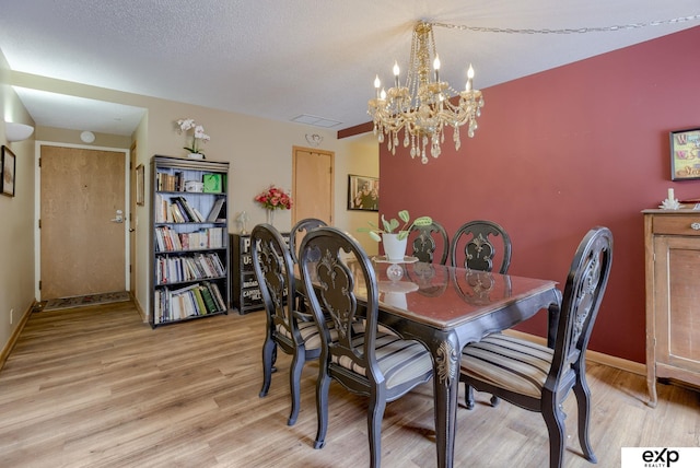 dining space with baseboards, a notable chandelier, visible vents, and light wood-style floors
