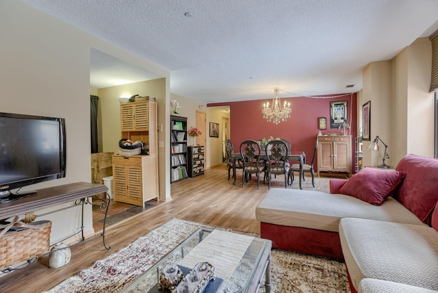 living room featuring a textured ceiling, wood finished floors, and a chandelier
