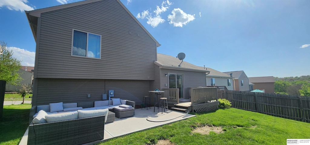 rear view of house featuring a wooden deck, a yard, an outdoor hangout area, and fence