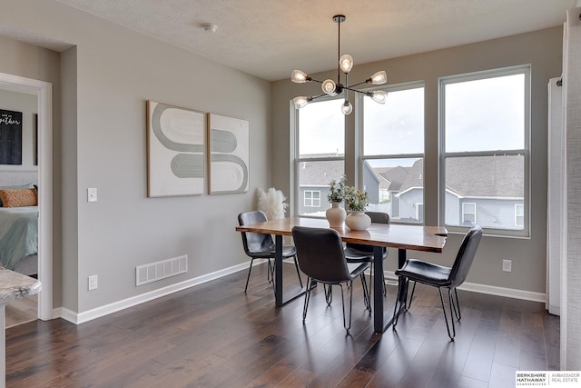 dining area with an inviting chandelier, baseboards, dark wood-type flooring, and visible vents