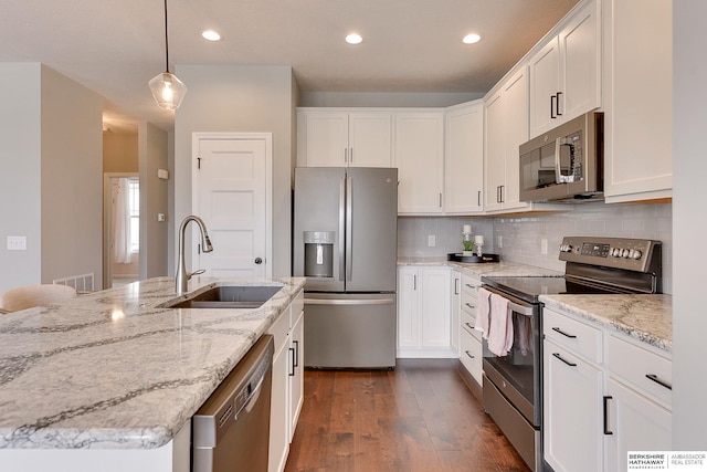 kitchen featuring a sink, stainless steel appliances, white cabinetry, tasteful backsplash, and dark wood-type flooring