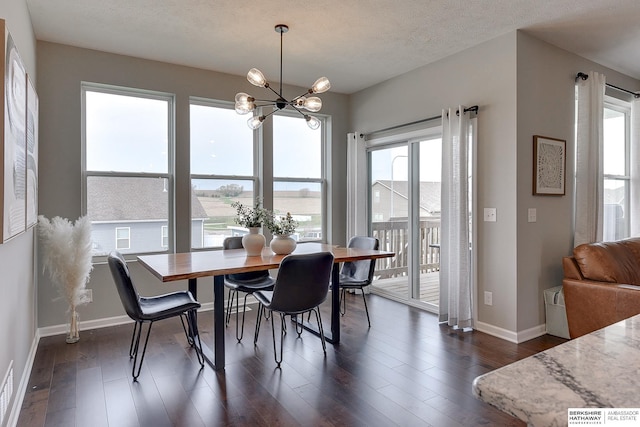 dining space with a textured ceiling, baseboards, a notable chandelier, and dark wood-style floors