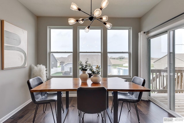 dining space with baseboards, dark wood finished floors, and a notable chandelier