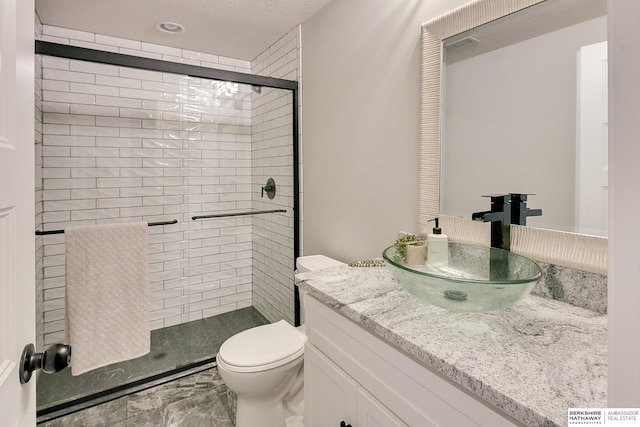 bathroom featuring vanity, toilet, marble finish floor, and a stall shower