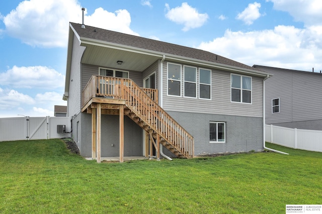 rear view of house featuring a deck, stairway, a fenced backyard, a gate, and a lawn