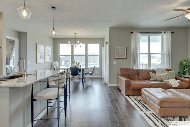 living room with plenty of natural light, a textured ceiling, and baseboards