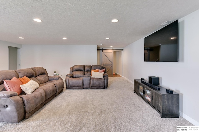 carpeted living area featuring recessed lighting, a barn door, baseboards, and a textured ceiling
