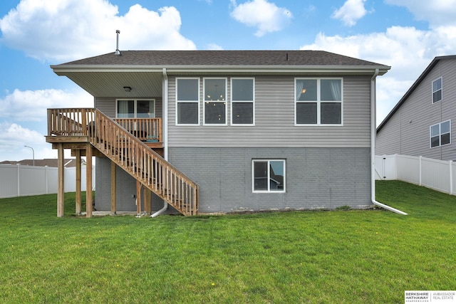 rear view of property featuring a yard, a deck, stairs, and a fenced backyard