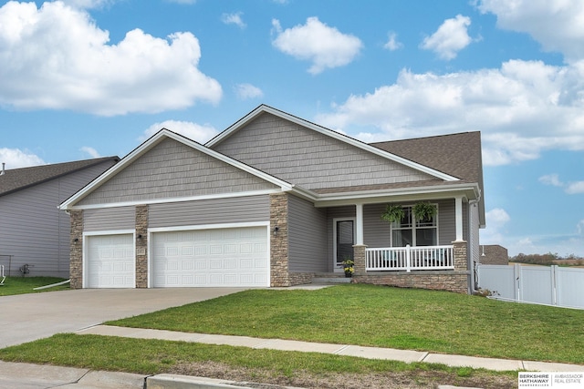 craftsman-style home with an attached garage, a front lawn, covered porch, and stone siding