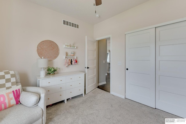 living area featuring a ceiling fan, visible vents, and light carpet