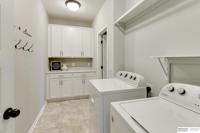 laundry area with baseboards, cabinet space, and washer and dryer