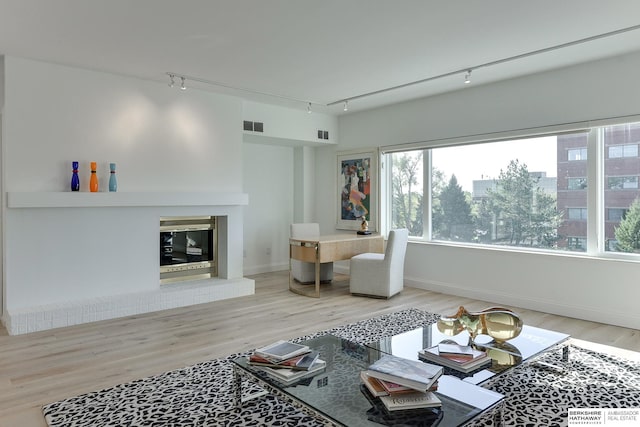 living room featuring baseboards, visible vents, track lighting, and wood finished floors