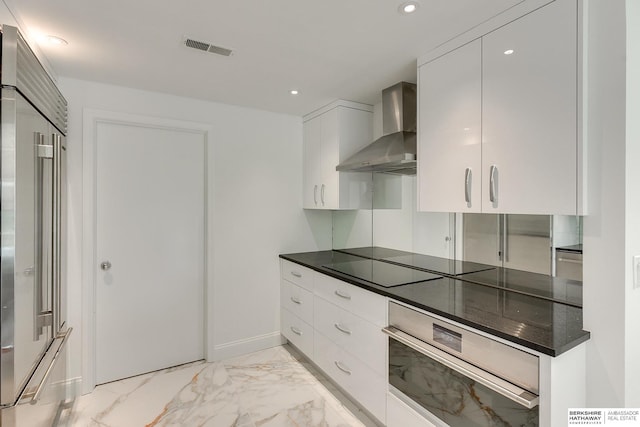 kitchen with wall chimney range hood, appliances with stainless steel finishes, marble finish floor, visible vents, and modern cabinets