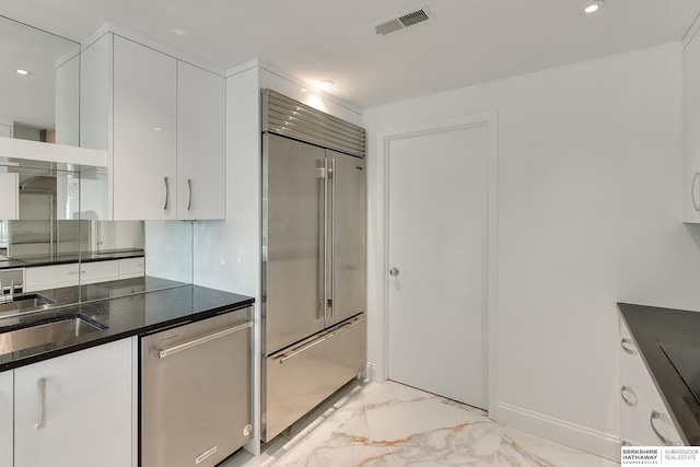 kitchen with white cabinets, appliances with stainless steel finishes, marble finish floor, recessed lighting, and visible vents