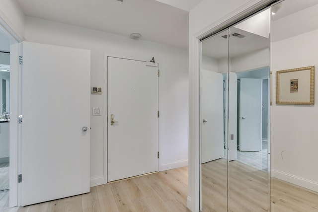interior space with visible vents, light wood finished floors, and baseboards