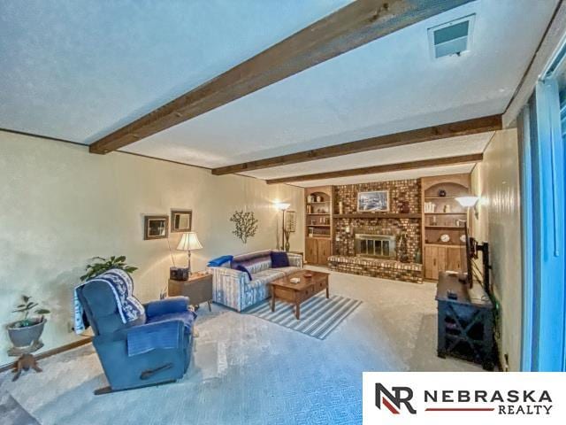 carpeted living area with a brick fireplace, beamed ceiling, and built in shelves