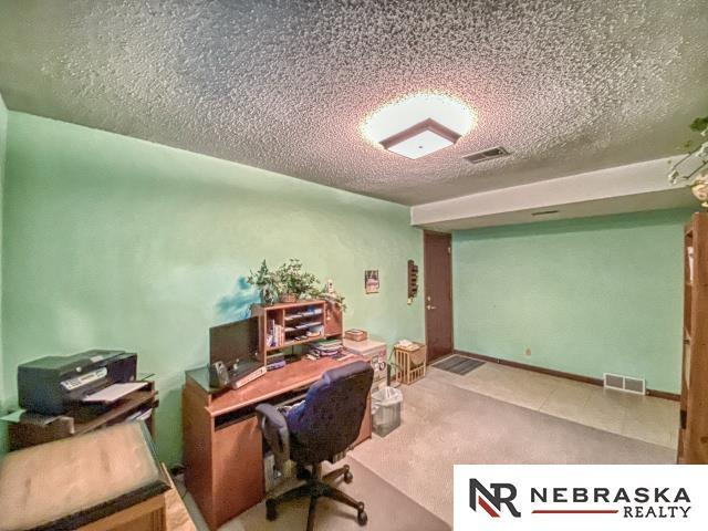 office with a textured ceiling and visible vents