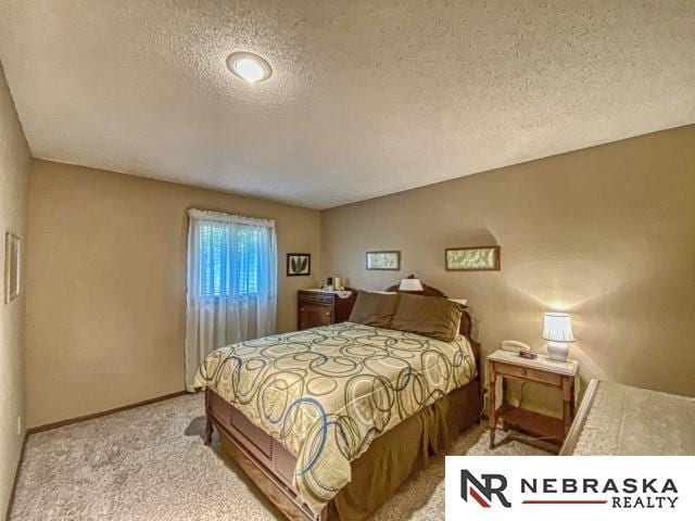 carpeted bedroom featuring baseboards and a textured ceiling