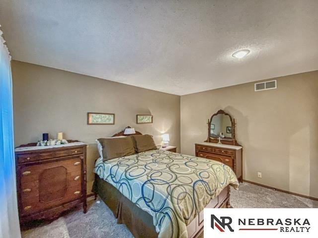 carpeted bedroom with visible vents and baseboards