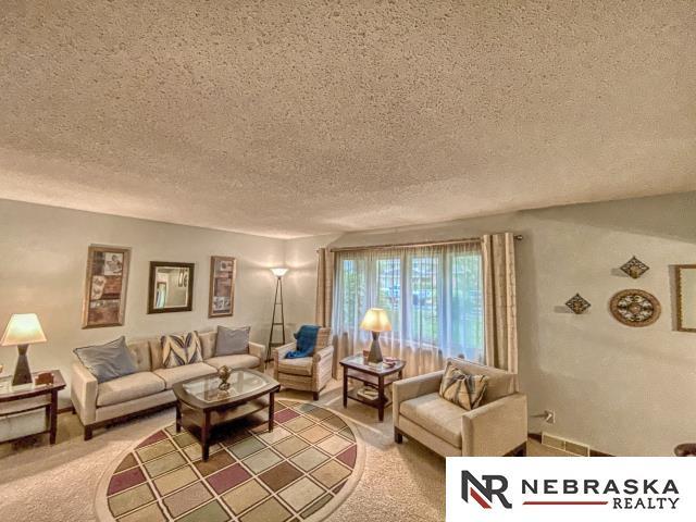 living area with a textured ceiling and light carpet