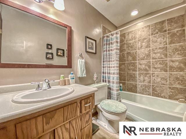 full bath with vanity, shower / bath combo, and toilet