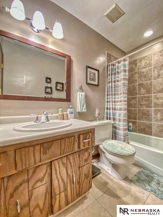 bathroom featuring tile patterned flooring, vanity, toilet, a textured ceiling, and visible vents