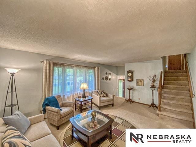 carpeted living room with baseboards, a textured ceiling, and stairway