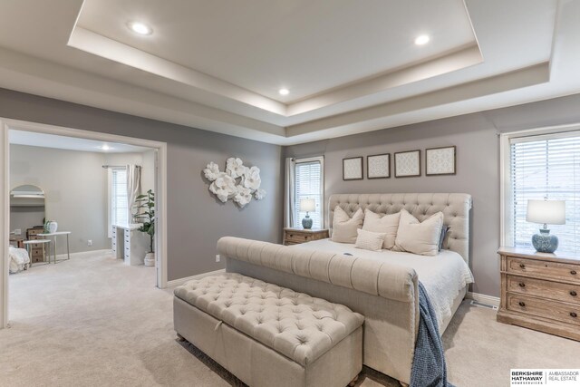 bedroom with a raised ceiling, baseboards, light carpet, and recessed lighting