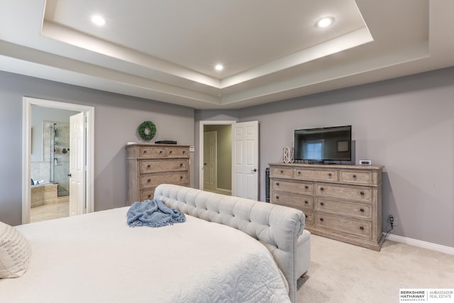 bedroom with light colored carpet, a raised ceiling, ensuite bath, recessed lighting, and baseboards