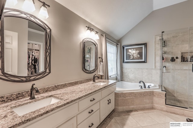 bathroom with a sink, a shower stall, vaulted ceiling, and a garden tub