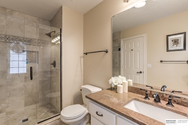 full bathroom featuring vanity, toilet, and a shower stall