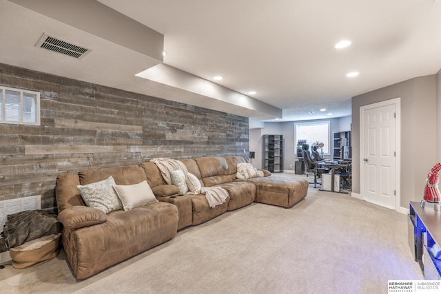 carpeted living area with recessed lighting, an accent wall, wood walls, and visible vents