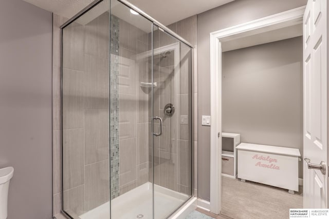 full bath with toilet and a stall shower