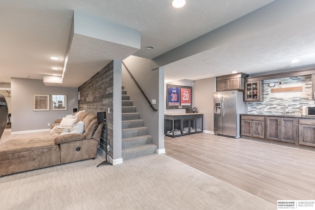 living area with recessed lighting, baseboards, stairway, and a textured ceiling