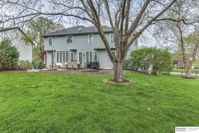 back of property with a lawn, fence, and a patio area