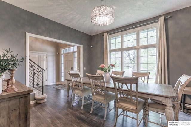 dining room with an inviting chandelier, a textured ceiling, baseboards, and dark wood-style floors
