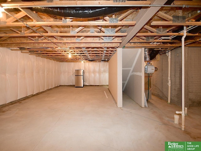 unfinished below grade area featuring freestanding refrigerator