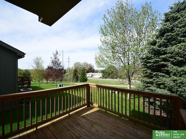 wooden deck featuring a lawn