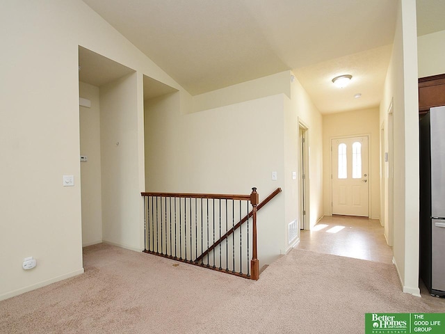 hallway with visible vents, carpet, baseboards, and an upstairs landing
