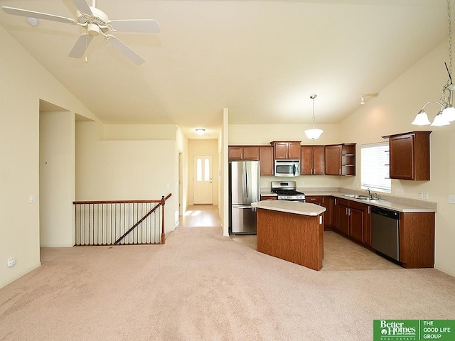 kitchen featuring a sink, appliances with stainless steel finishes, vaulted ceiling, and light carpet