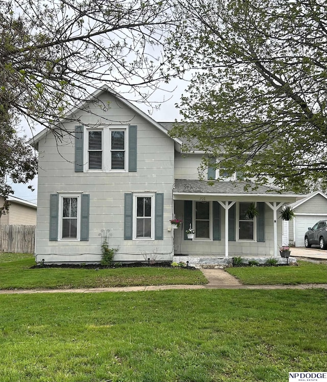traditional-style home featuring a front lawn and fence