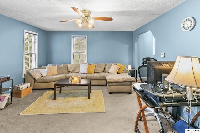 carpeted living room featuring a textured ceiling and ceiling fan